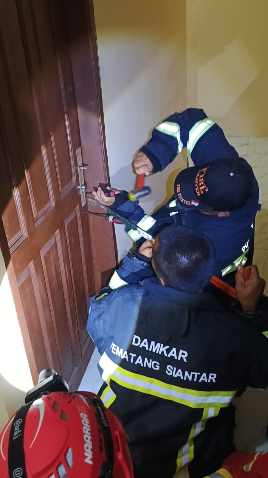 evakuasi pintu kamar milik warga yang terkunci yang beralamat di  Jl. Asahan No.km 4