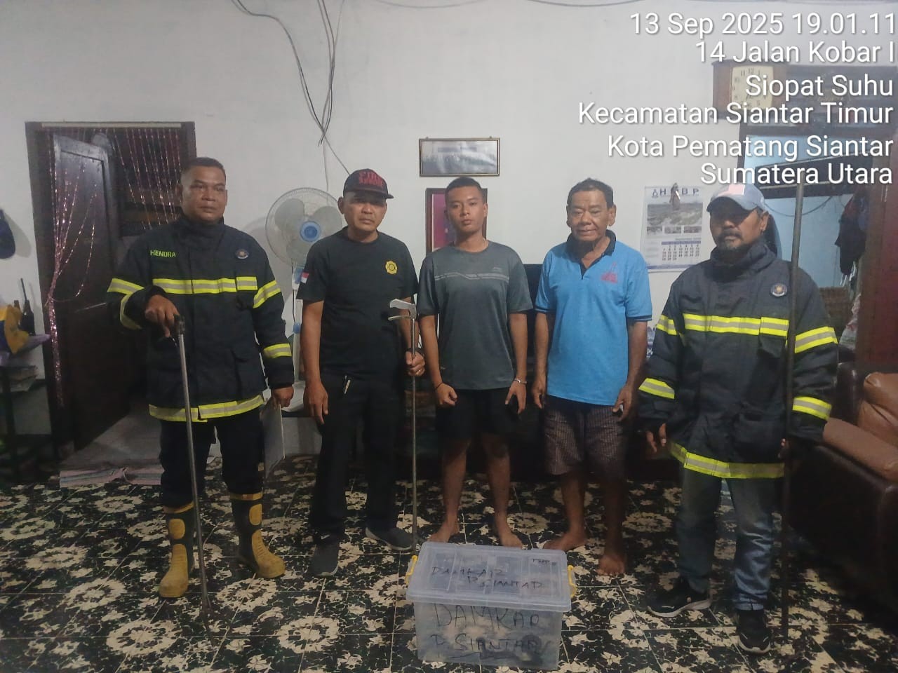 Personil Dinas Pemadam Kebakaran dan Penyelamatan berhasil mengevakuasi seekor ular dirumah warga