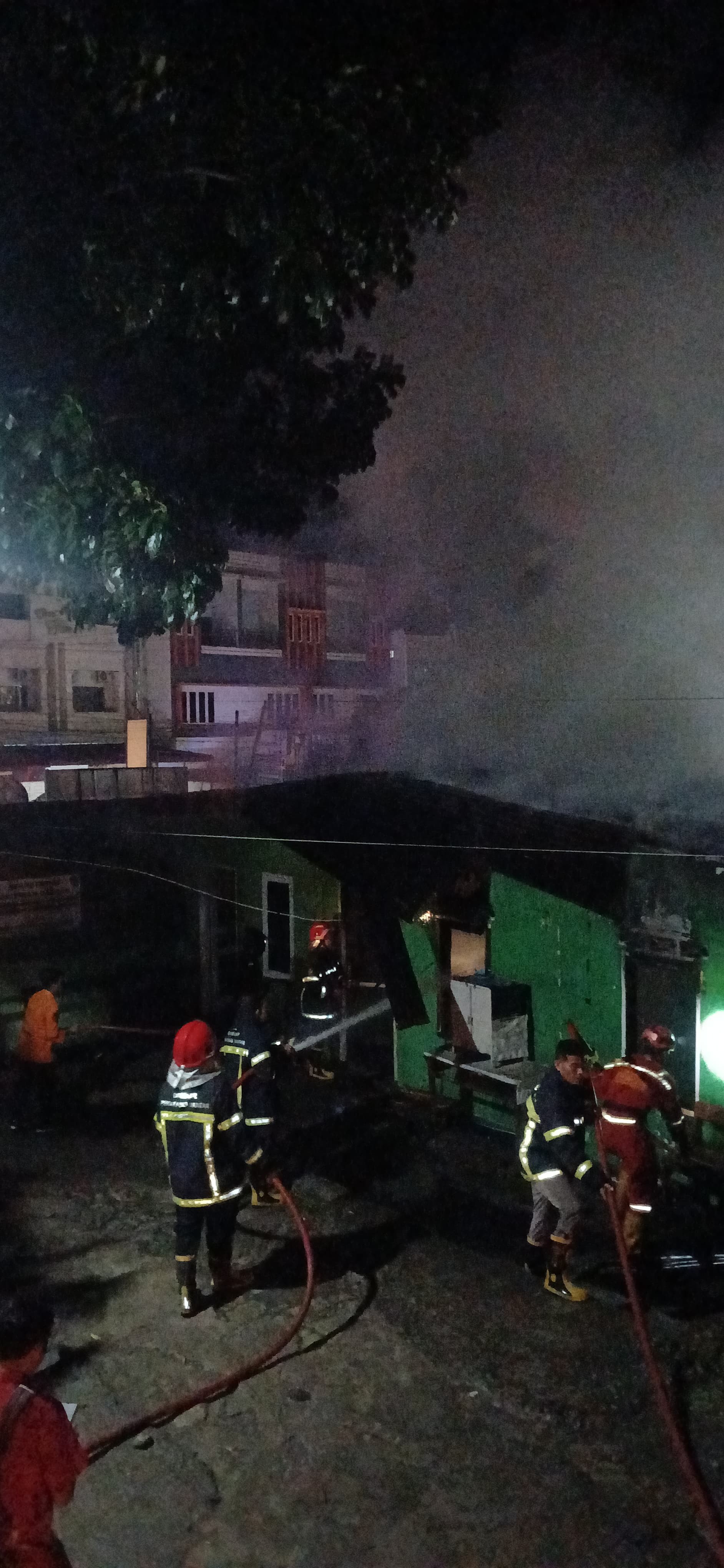 Personil Dinas Pemadam Kebakaran dan Penyelamatan melaksanakan pemadaman kebakaran rumah di Jl. Ra