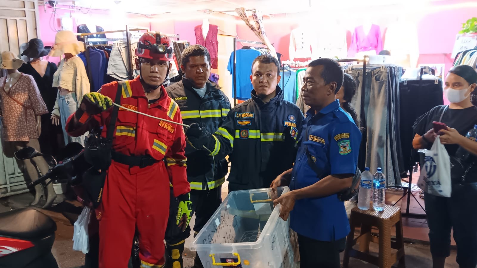 Personil Dinas Pemadam Kebakaran dan Penyelamatan berhasil mengevakuasi seekor  ular di Toko Pakaian