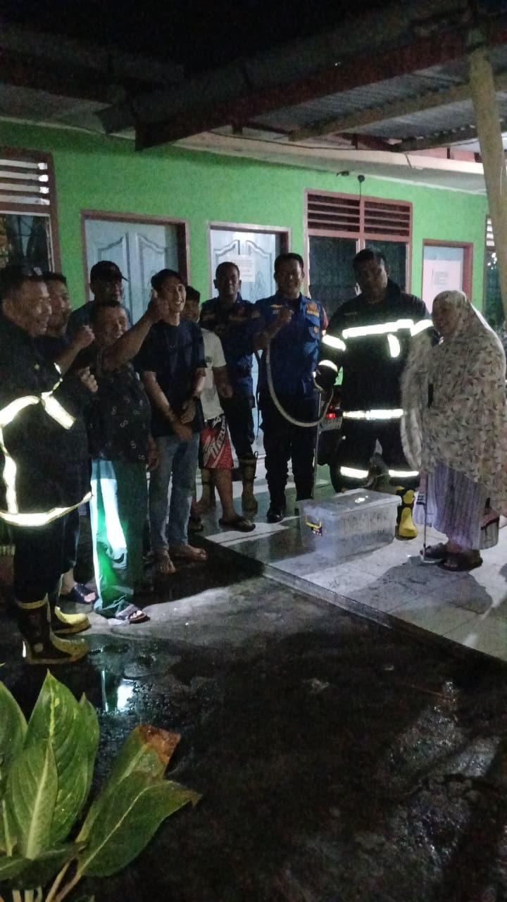 Personil Dinas Pemadam Kebakaran dan Penyelamatan berhasil mengevakuasi ular di rumah warga  Jl. Kar