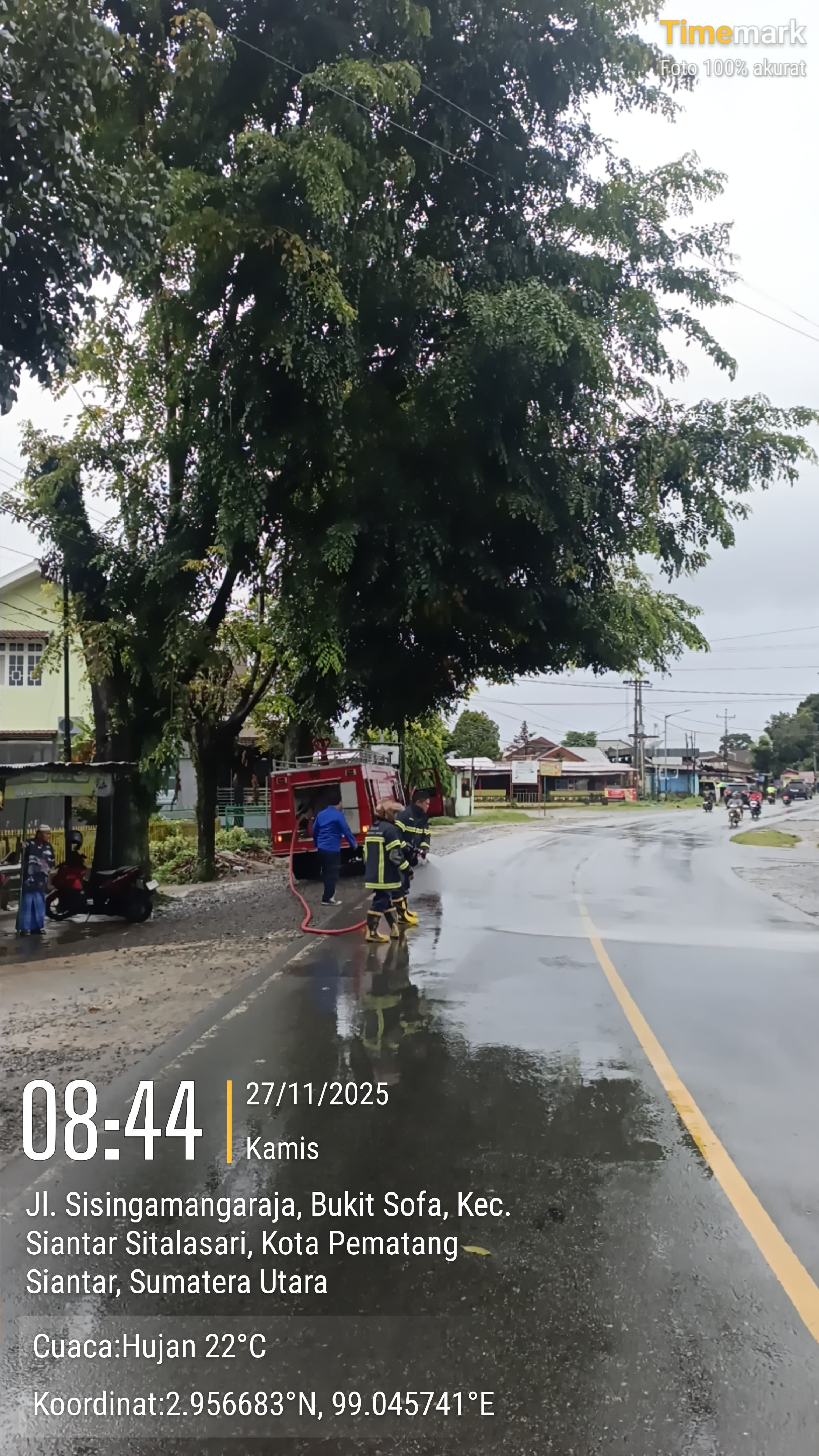 Personil Dinas Pemadam Kebakaran dan Penyelamatan melaksanakan giat penyemprotan jalan diduga adanya
