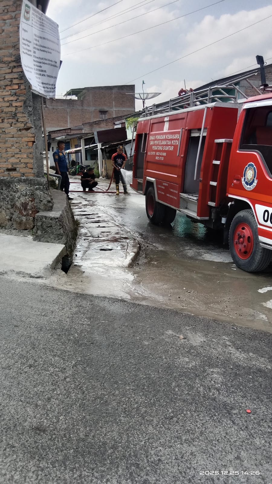 Personil Dinas Pemadam Kebakaran dan Penyelamatan melaksanakan penyemprotan jalan yang berdebu di  J