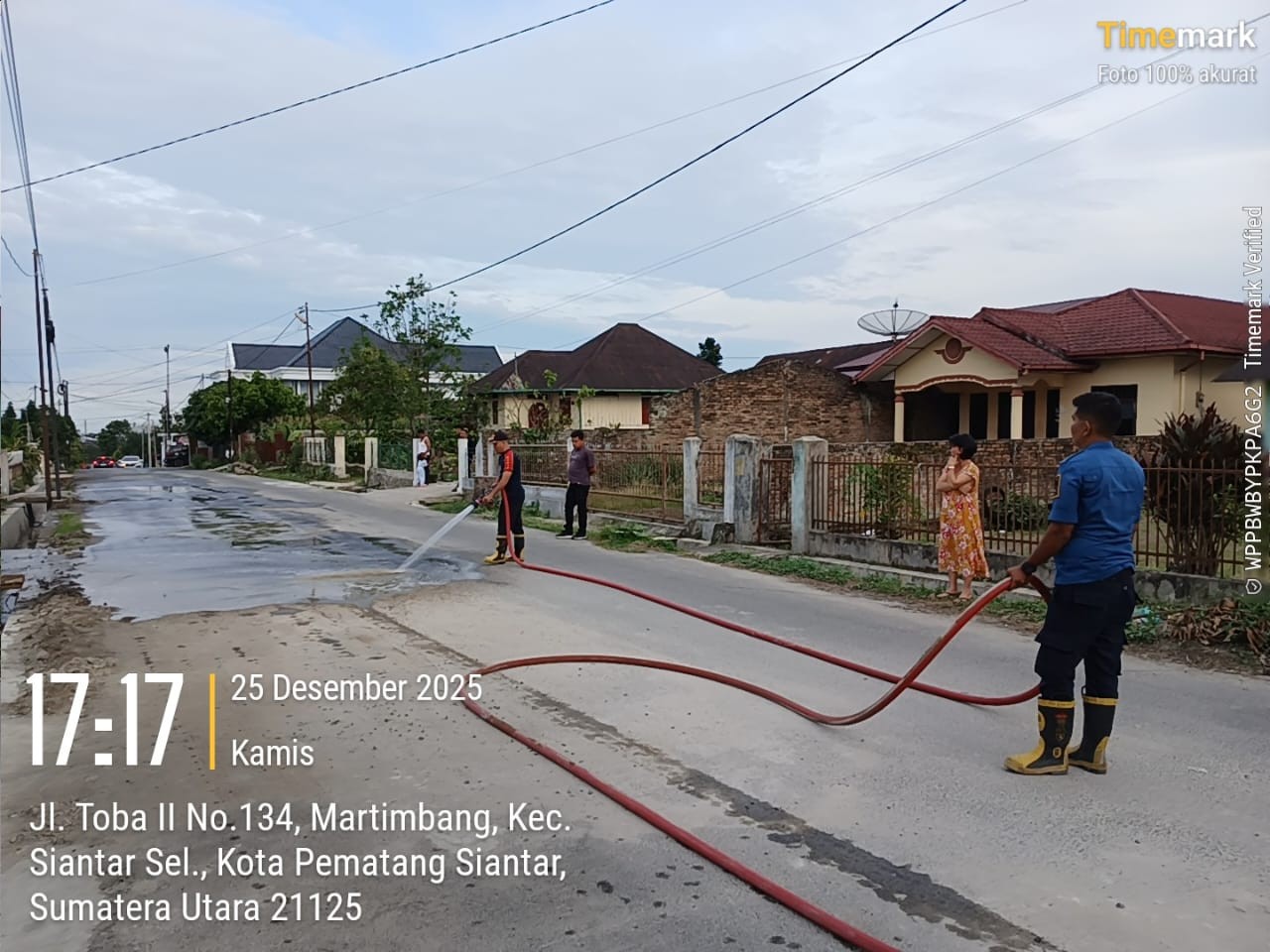Personil Dinas Pemadam Kebakaran dan Penyelamatan melaksanakan penyemprotan jalan yang berdebu di  J