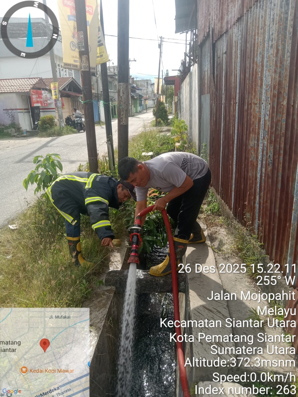 Personil Dinas Pemadam Kebakaran dan Penyelamatan melaksanakan penyemprotan parit yang tersumbat di 