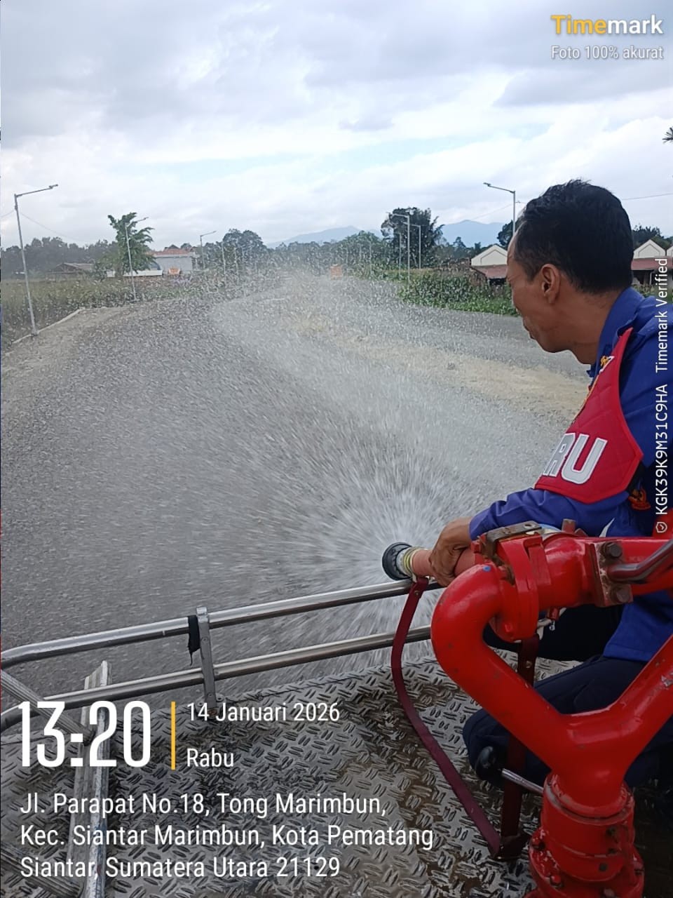 Personil Dinas Pemadam Kebakaran dan Penyelamatan melaksanakan penyiraman jalan yang berdebu yang me