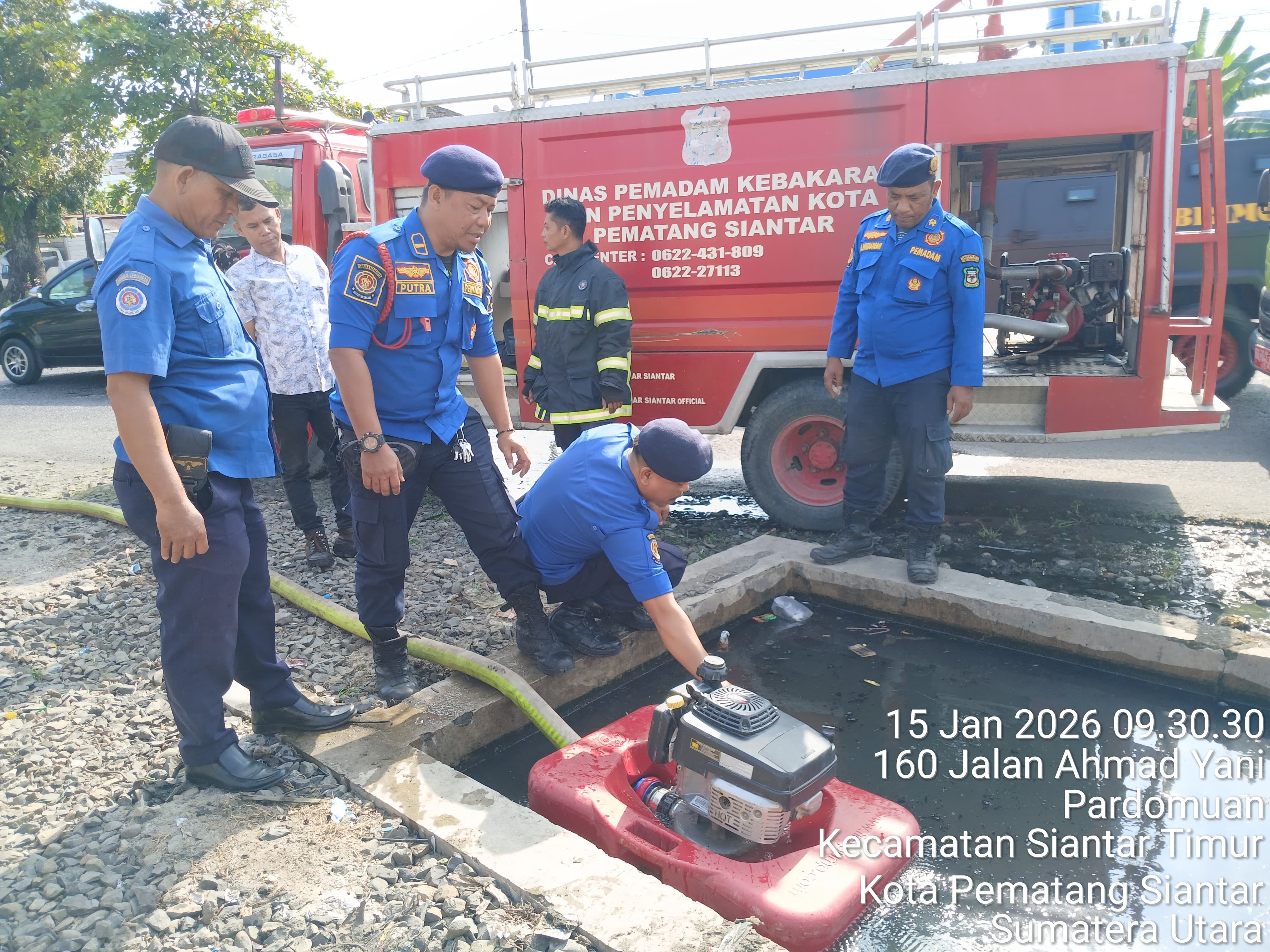 Personil Dinas Pemadam Kebakaran dan Penyelamatan melaksanakan penyemprotan parit yang tersumbat di 