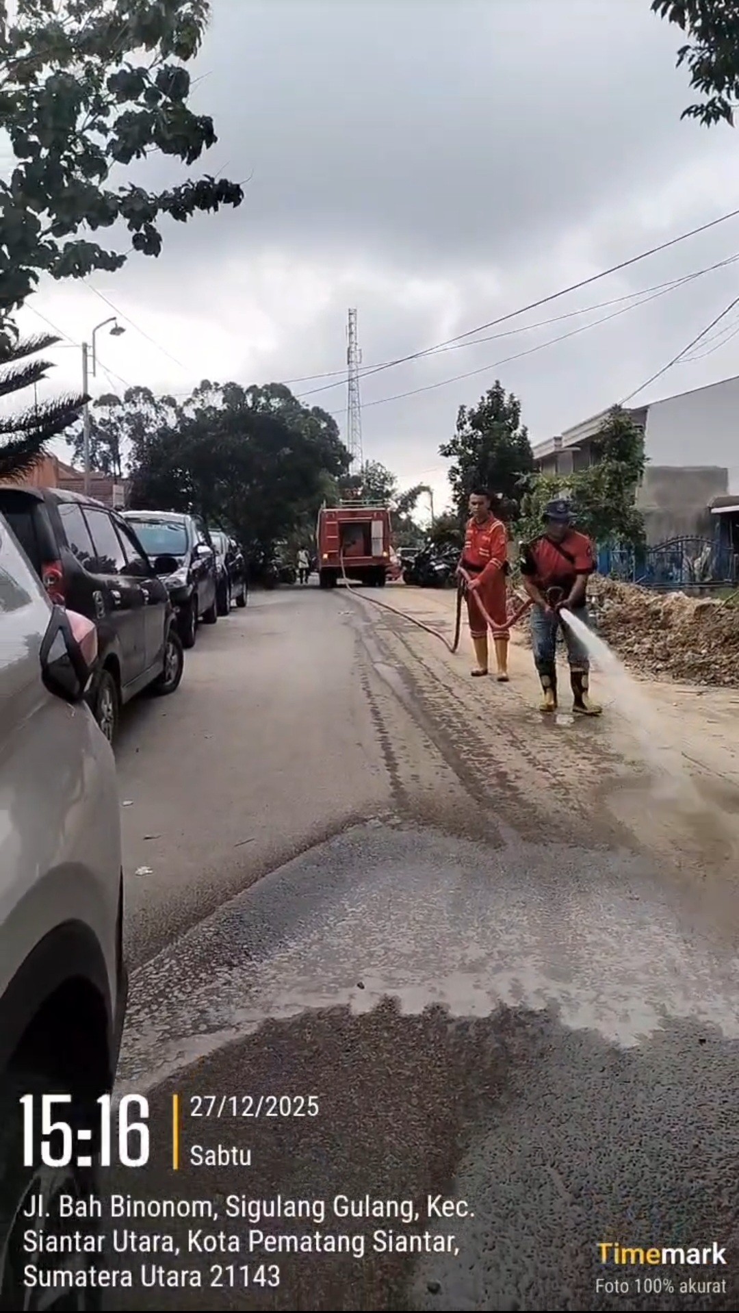 Personil Dinas Pemadam Kebakaran dan Penyelamatan melaksanakan penyemprotan jalan yang berdebu di  J